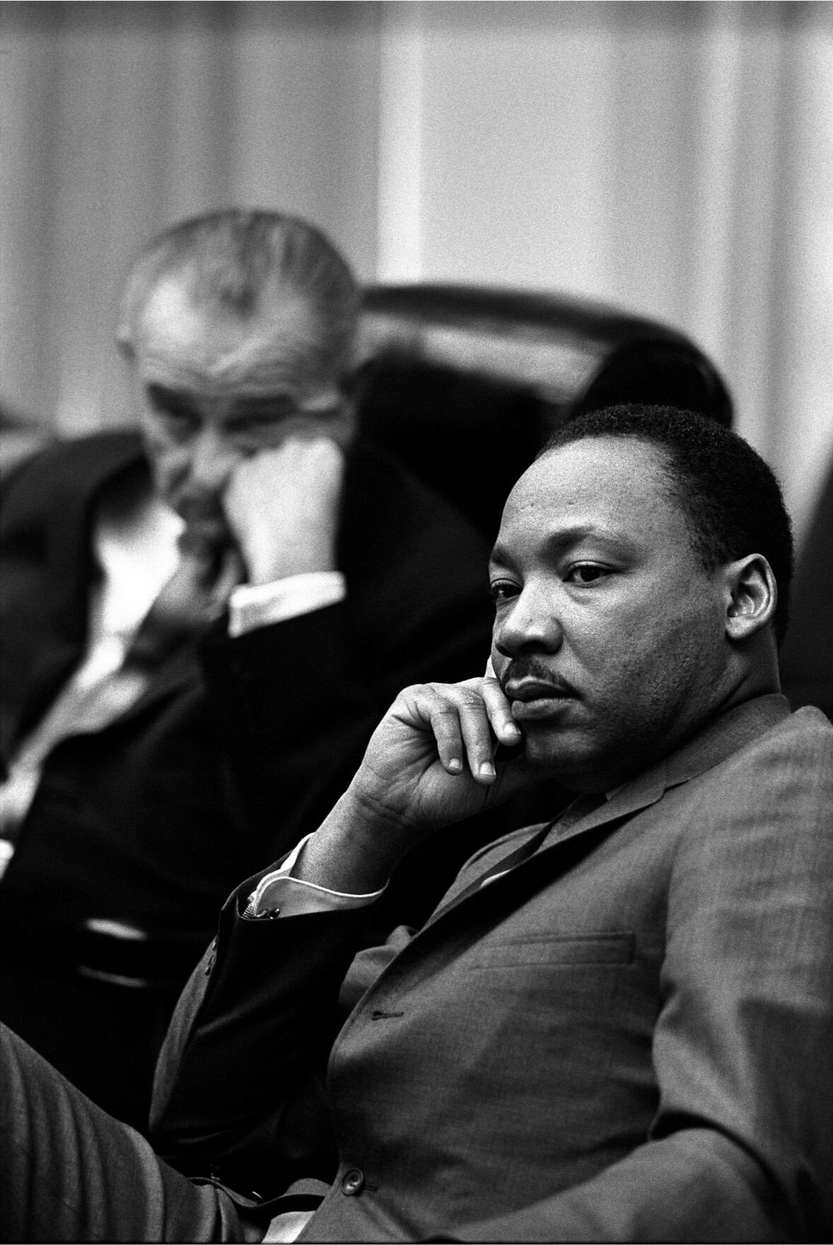Photograph of MLK with Lyndon B Johnson looking in the background.