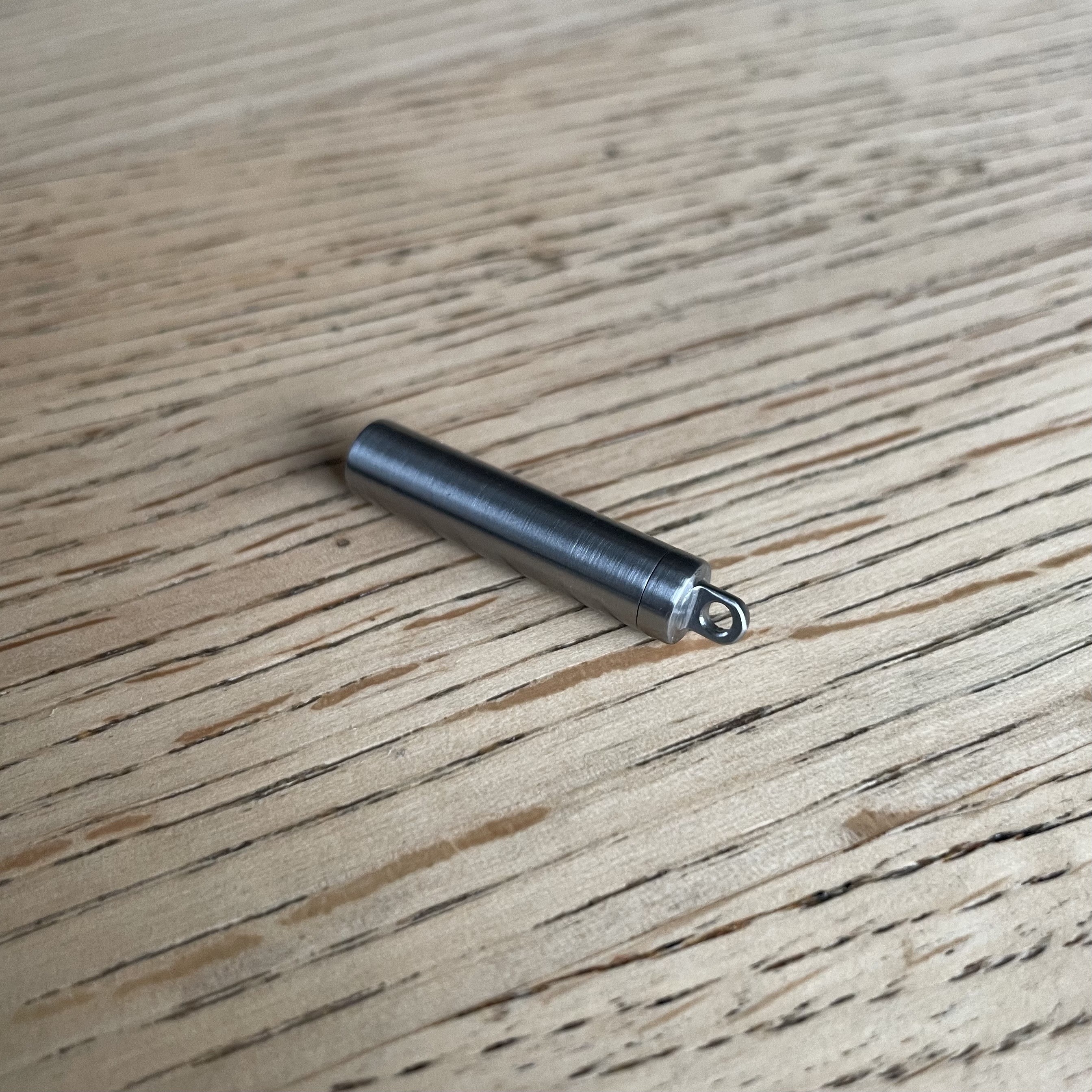 a small steel capsule on a wooden table