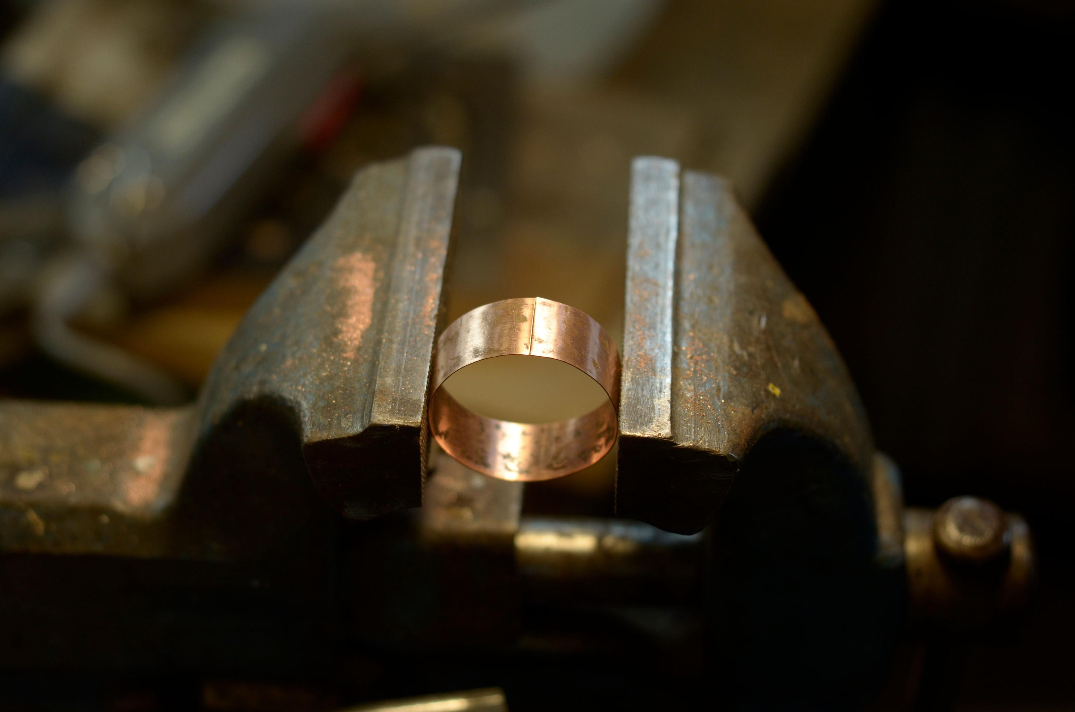 A ring of copper in a bench vise, ready to solder the seam.