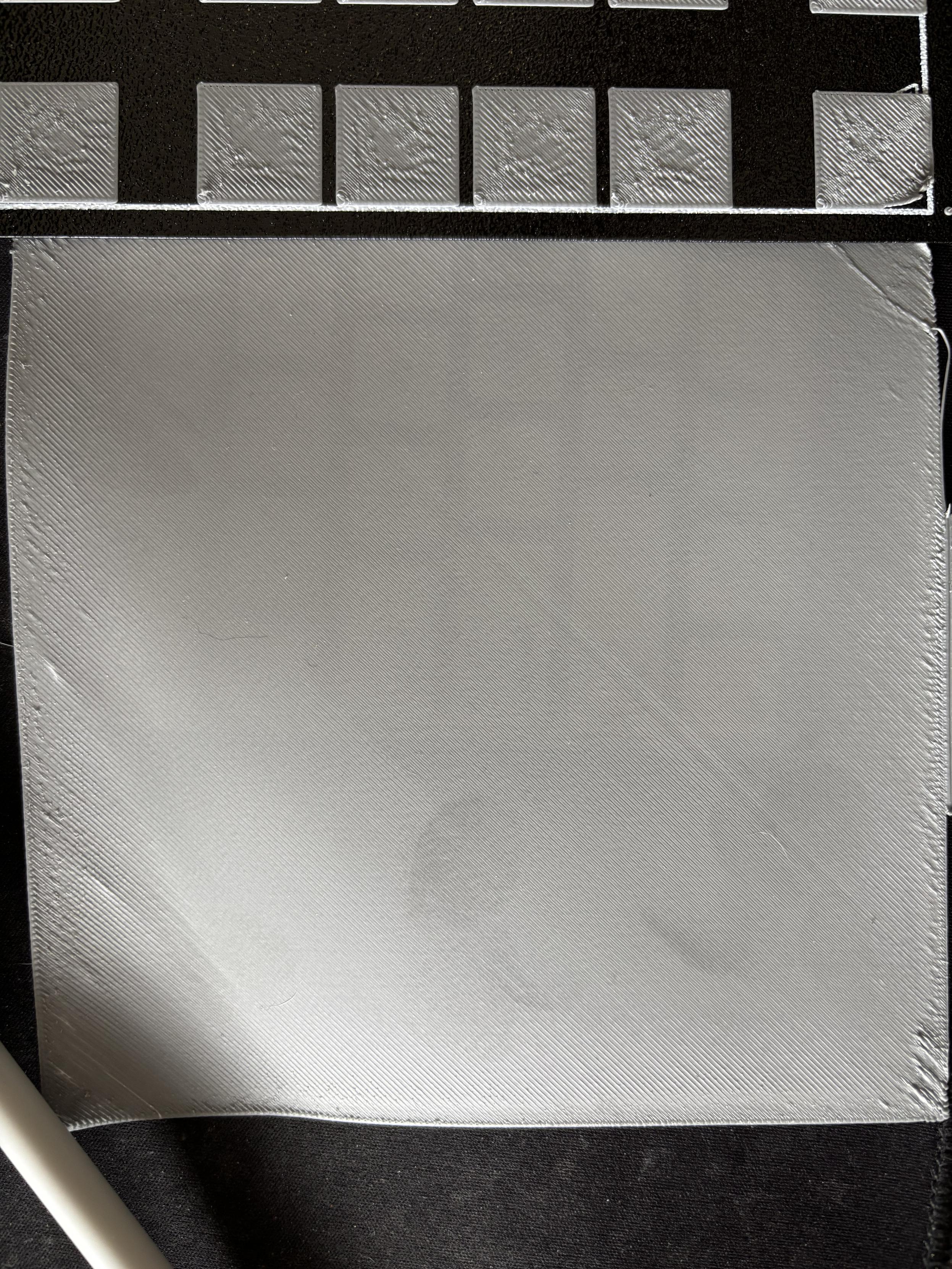 Closeup of a large square of a single layer of ABS plastic. It’s mostly uniform in texture except at the edges