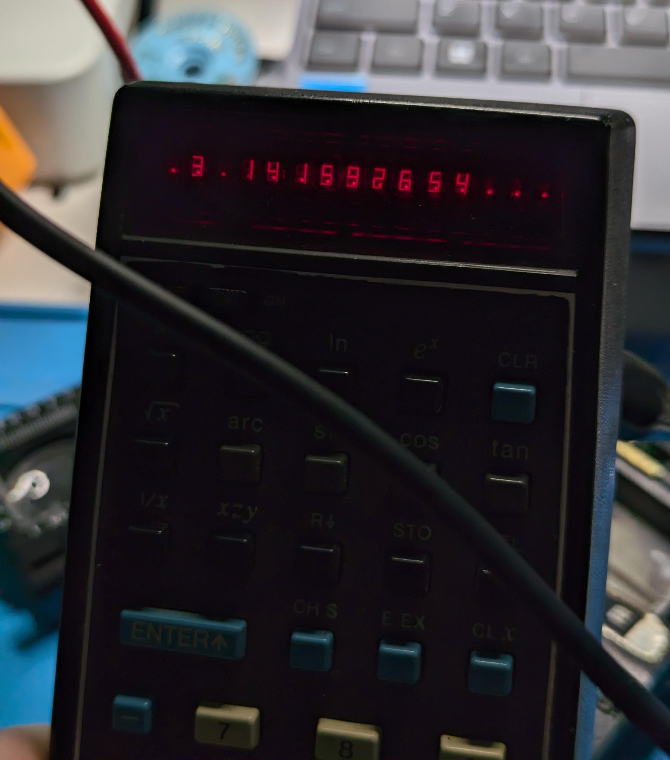 A silhouette view of an old calculator. The display dimly but sharply shows the digits of pi, with some noise and extra dots.