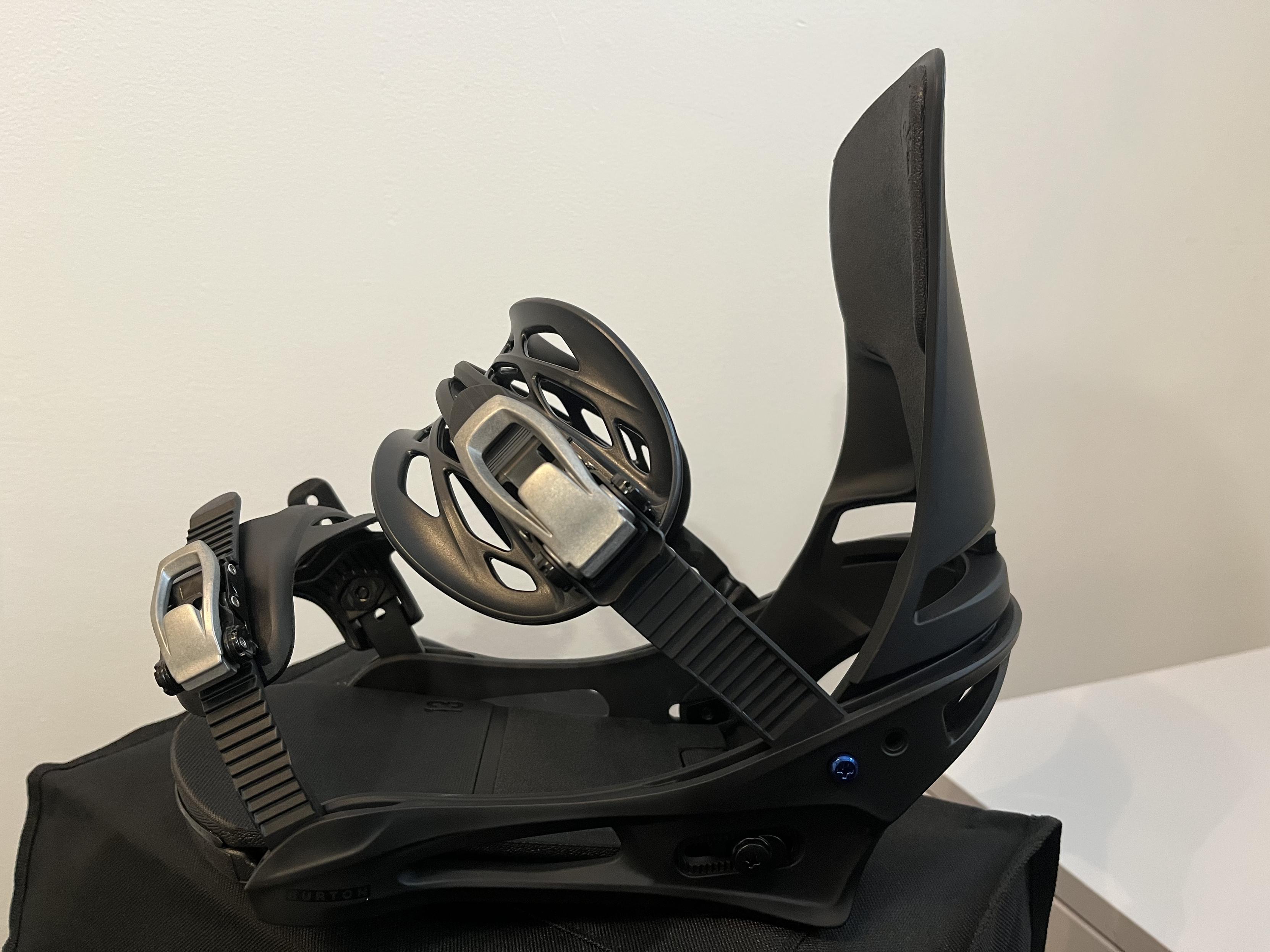 Side angle of one black Burton Cartel snowboard binding on a white background.