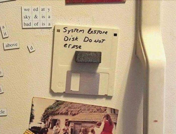 a floppy held to a fridge by a magnet, labeled "System Restore Disk Do not erase"