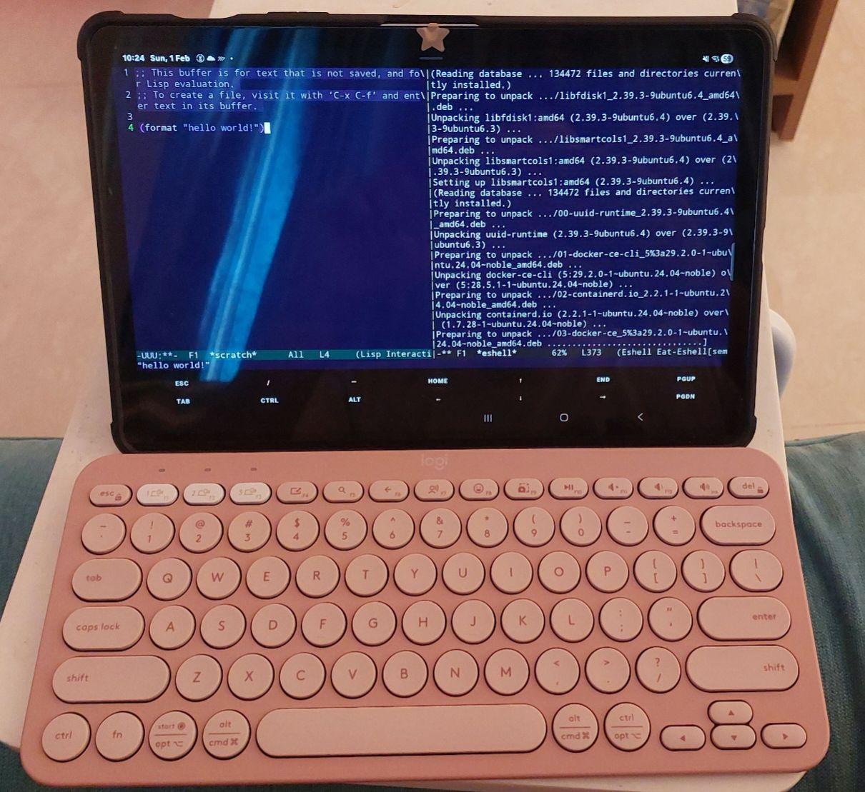 TUI Emacs open on an android tablet, hello world in a lisp buffer on the left, packages being updated via SSH on the right. Below there is a cute Bluetooth keyboard