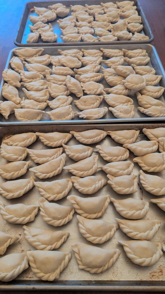 three half-sheet pans filled with 100+ pierogi