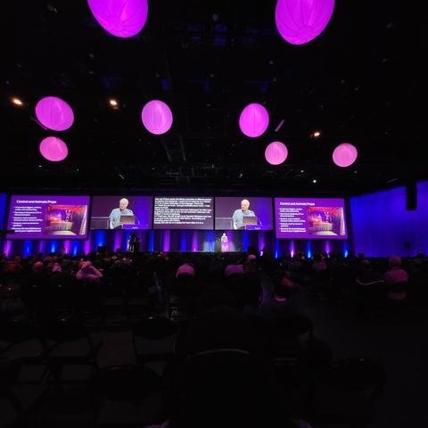 Photo of a speaker at the PyCon US lightning talks showing off automation of motorized prop control for Halloween decorations 