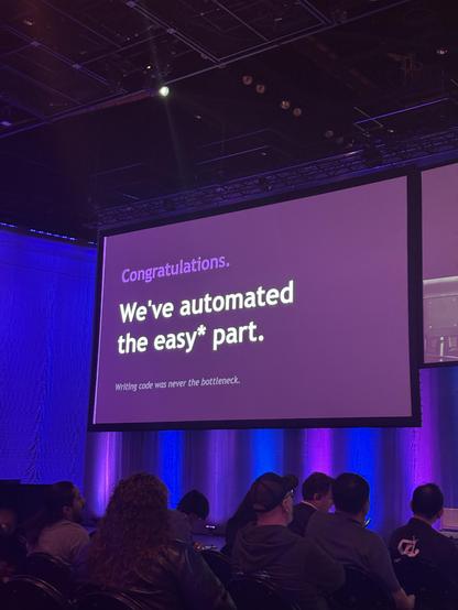 A slide that says "Congratulations. We've automated the easy* part. Writing code was never the bottleneck"