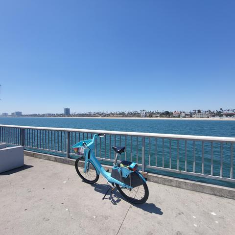 Photo of a bikeshare bike on a pier in Long Beach, facing back towards shore
