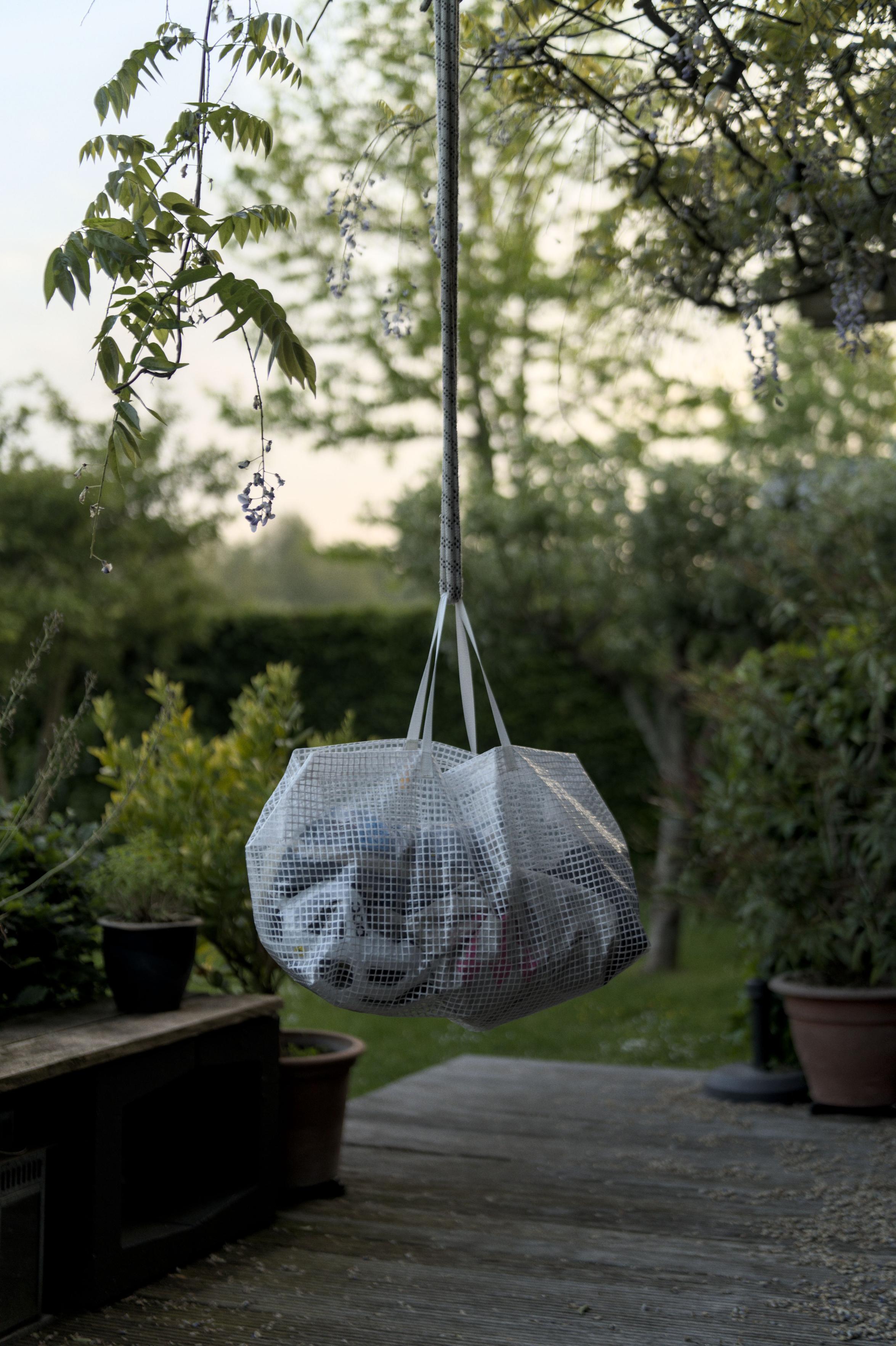 The bag hangs. Portrait crop. There is a soft
							 evening sky and the bag is in lower light but
							 still stands out from the garden background in an
							 interesting way.