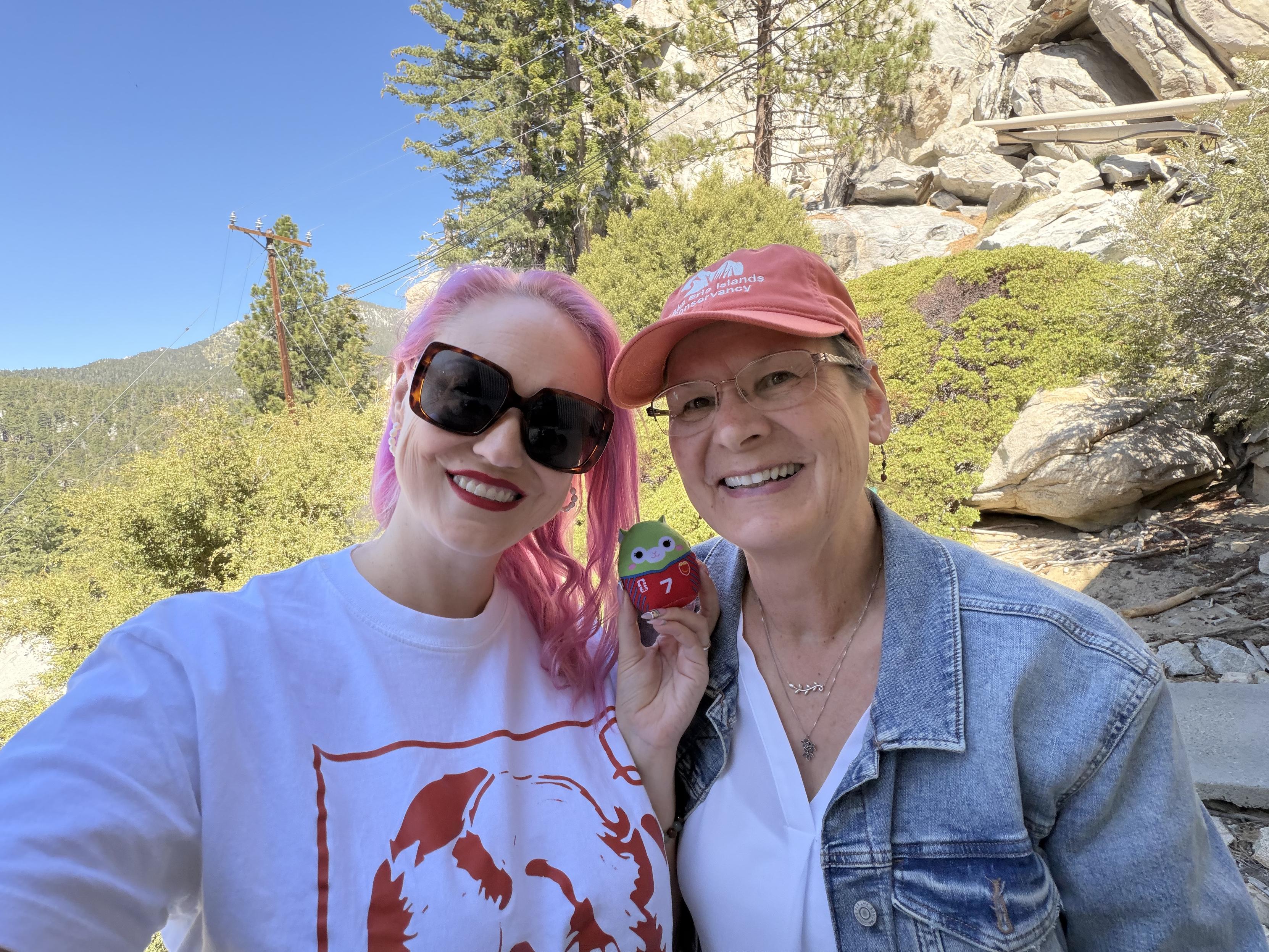 Woman with pink hair and her lovely momma in a denim jacket and orange hat