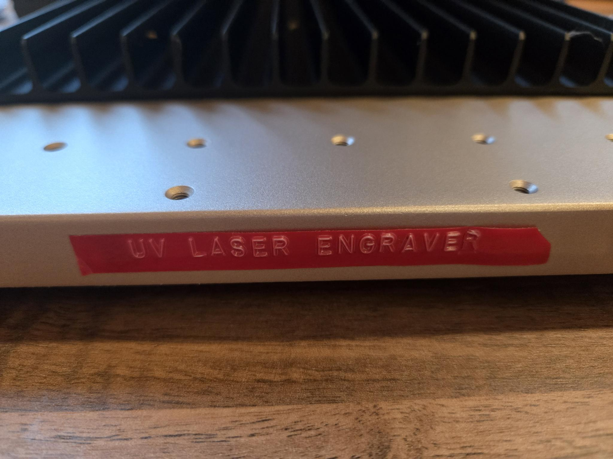 The front of the laser engraver with a red embossed label that reads "UV laser engraver".