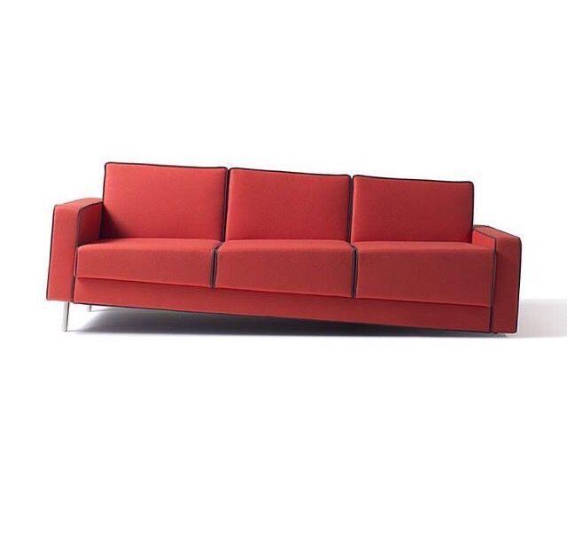 Photo of a tilted red couch, but the seating part is leaning upwards in such a way that it is level. It's horrible... I love it