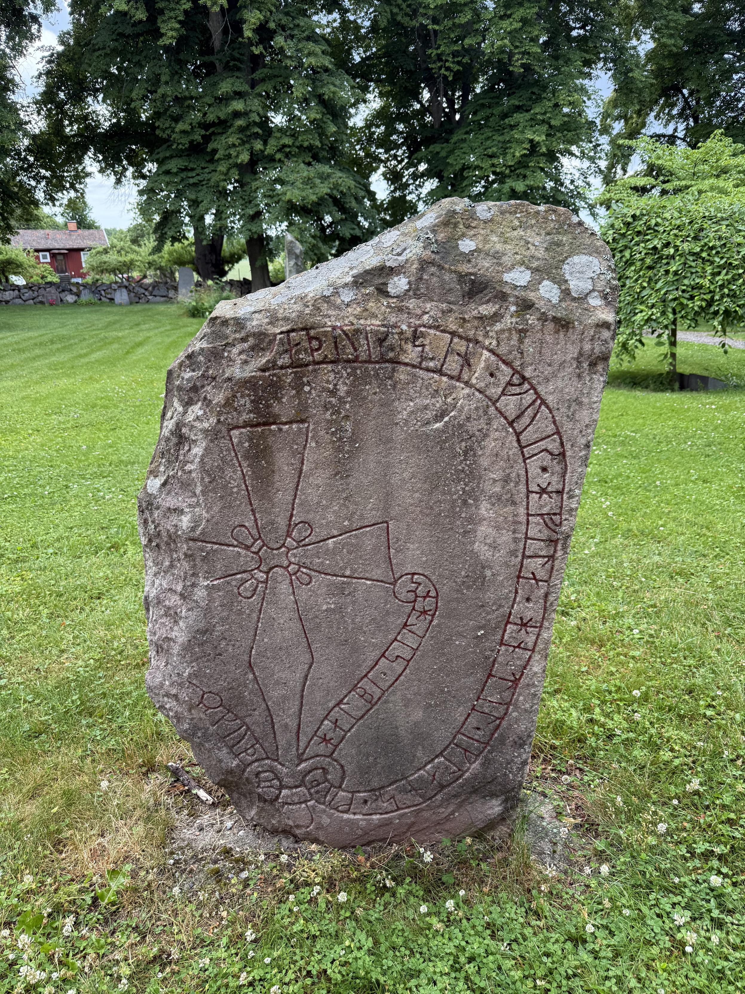 Photo of the runestone Sö 207 from the front. The left side of the stone has been broken off.
