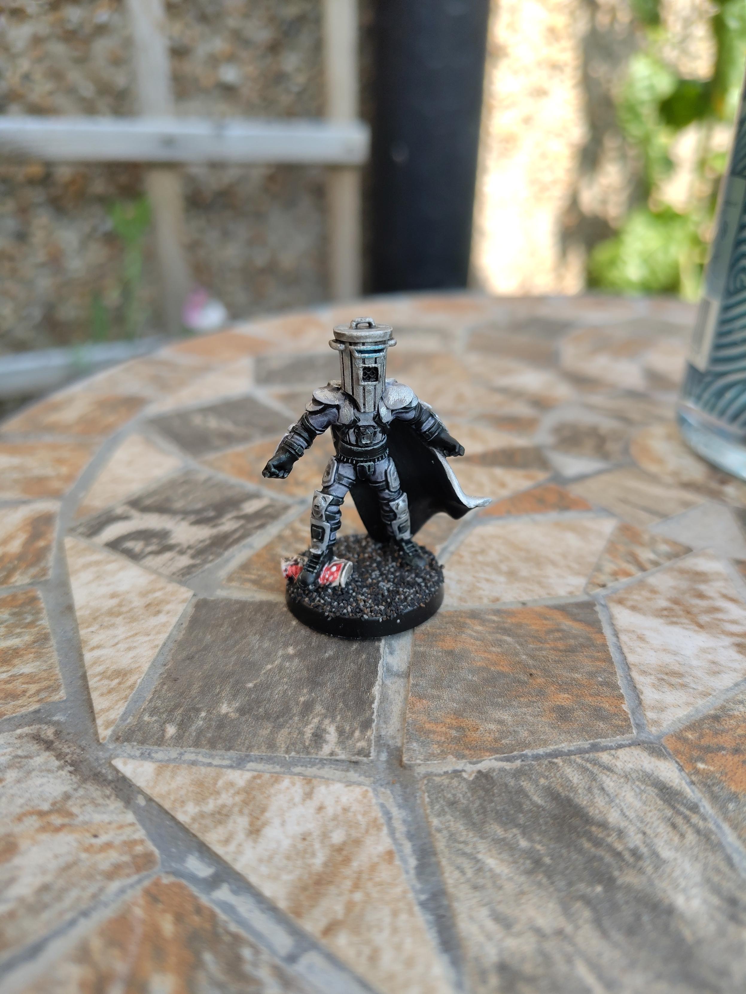 A painted miniature of Count Binface standing on a garden table.