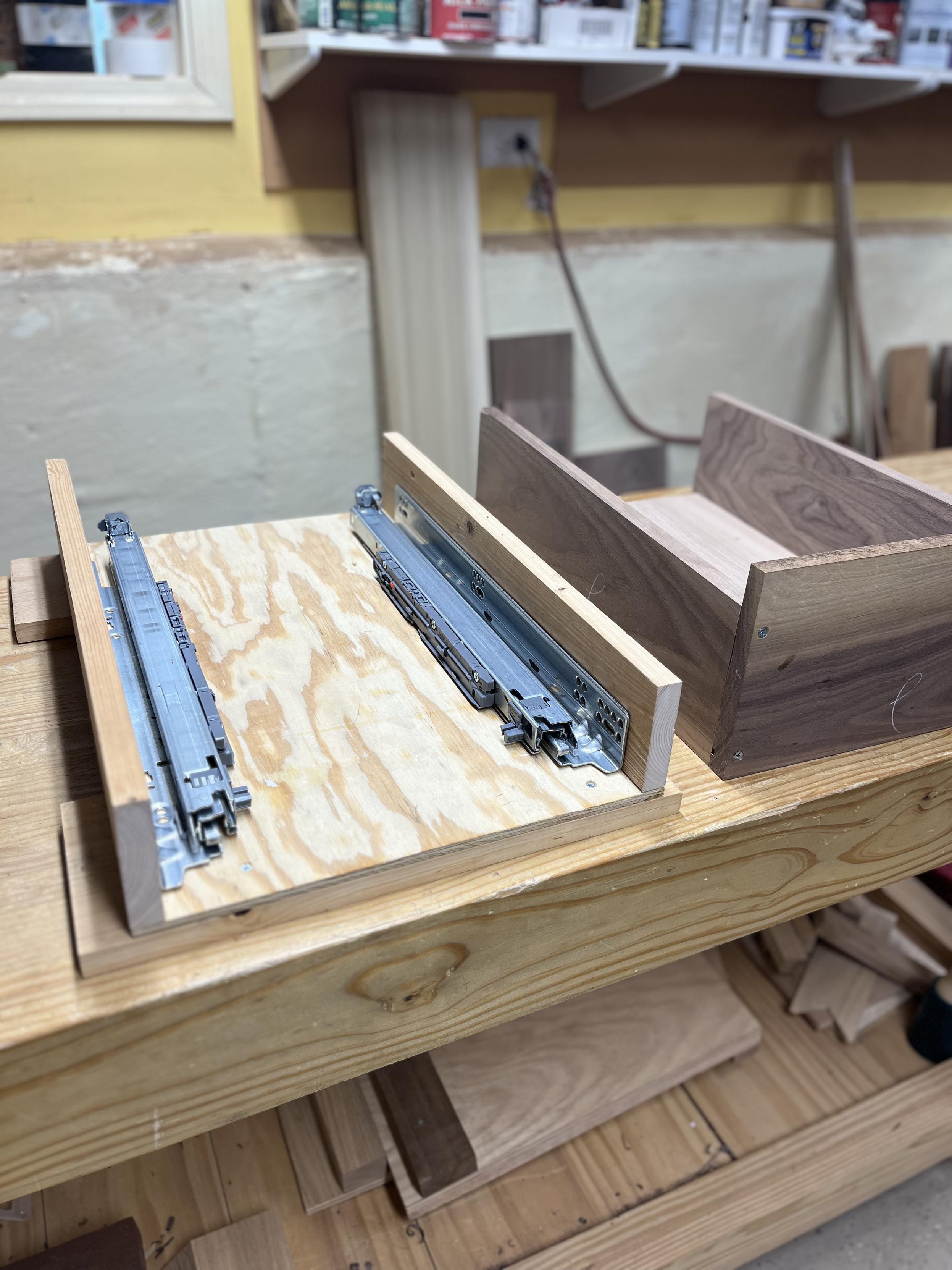 On the left, Blum drawer slides inside of a test box made of low grade wood. On the right, a test box made of walnut and assembled using but joints.
