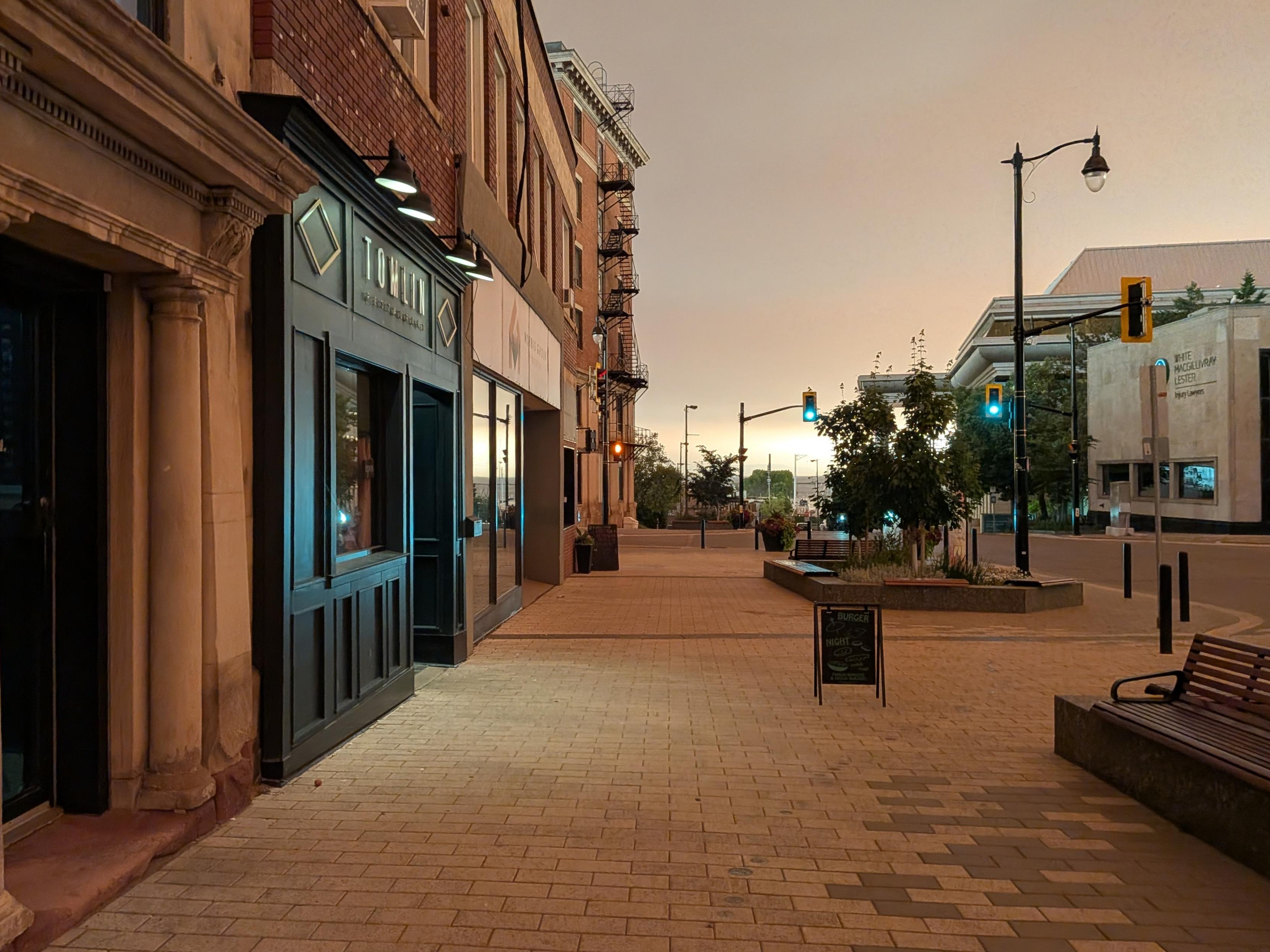 A empty city street tinted to an eerie orange by wildfire smoke