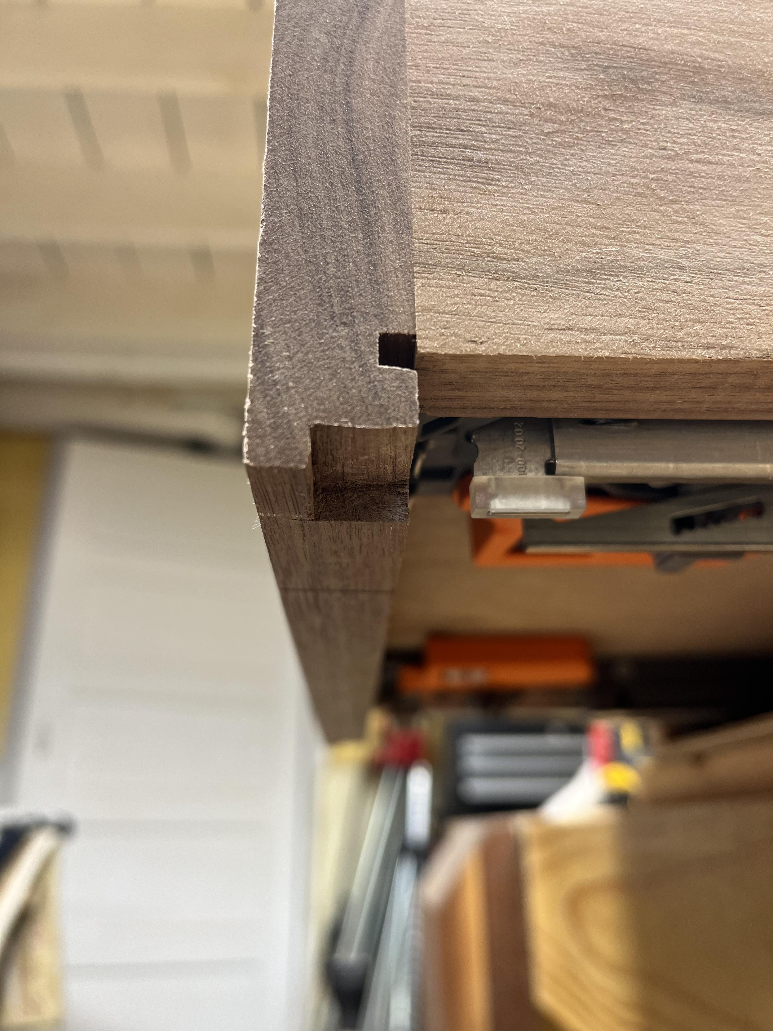A drawer open and a view of the side of the front showing a small notch at the bottom where the front overhangs.