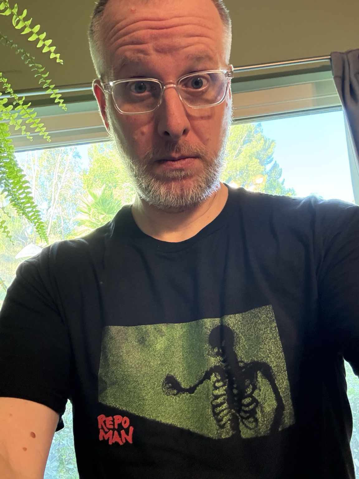A man in a Repo Man shirt